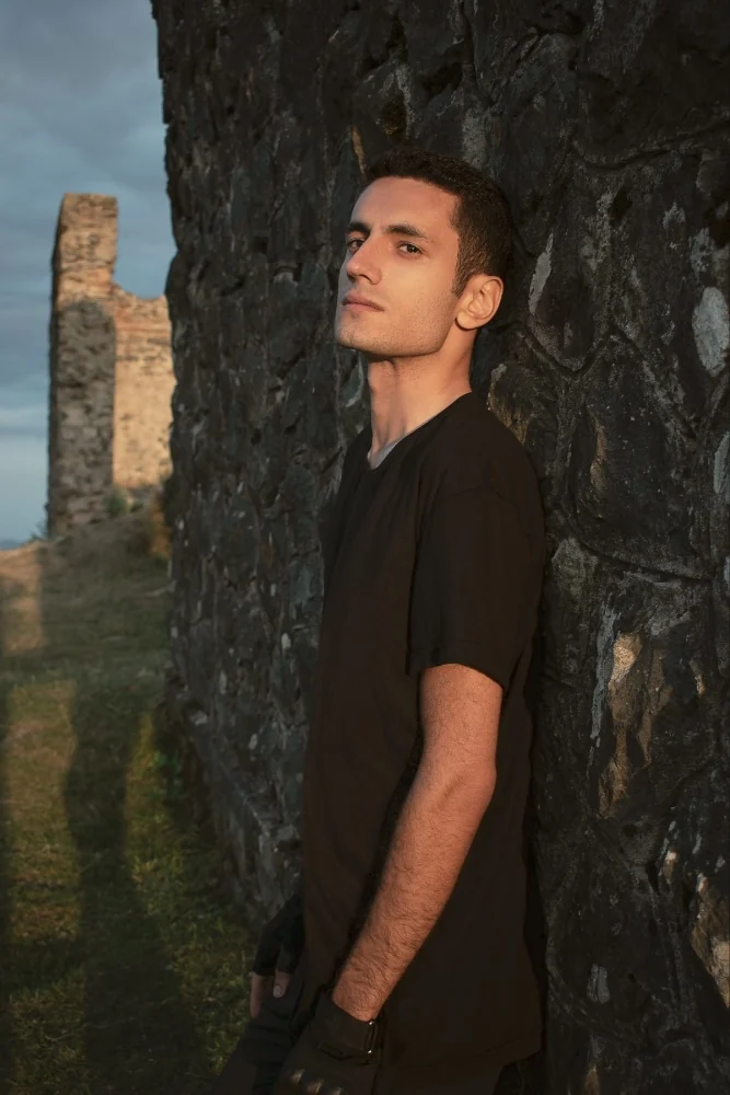 Portrait of a man beside a stone wall